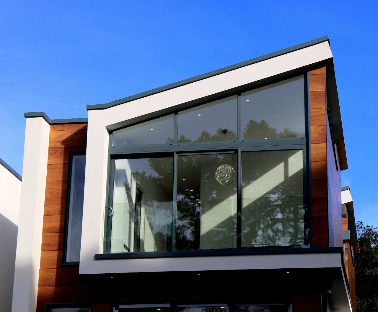 Accueil Contemporary house in Poole, UK featuring a sleek design with large glass windows and wood paneling.